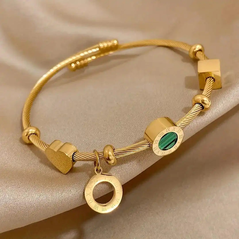 Pulsera de dijes en oro con esmeralda