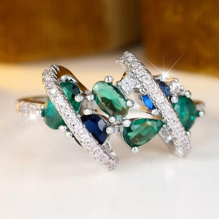 Anillo entrelazado de esmeralda con varias piedras