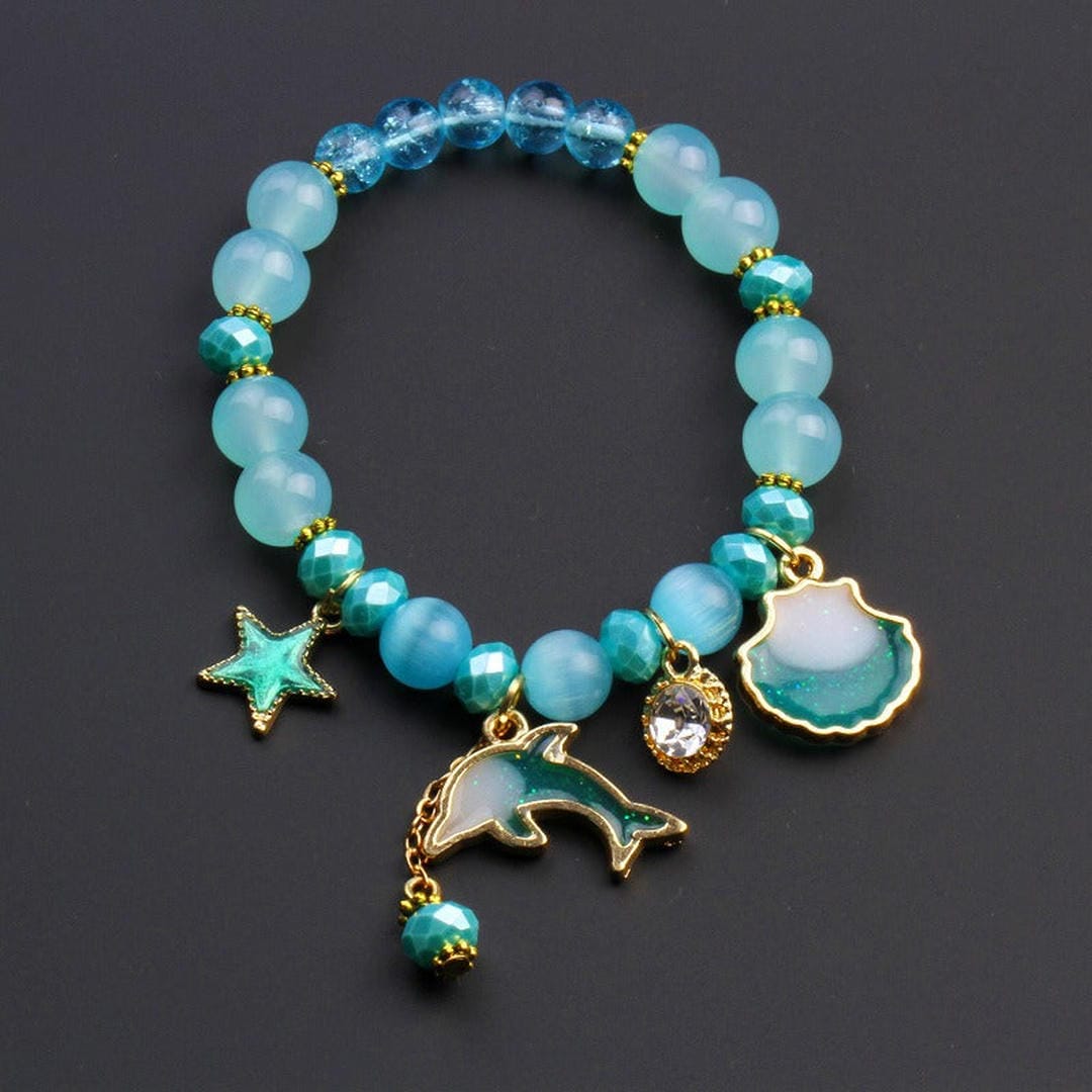 Pulsera de cuentas con dije de delfín y concha