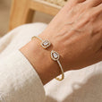 Pulsera rígida abierta de oro con dos piedras