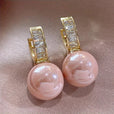 Pendientes huggie de perla rosa con baguettes