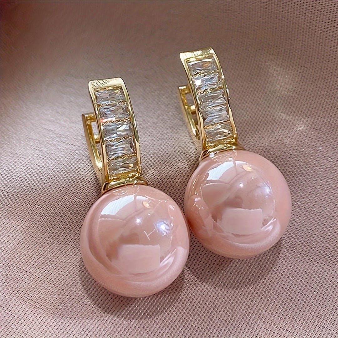 Pendientes huggie de perla rosa con baguettes