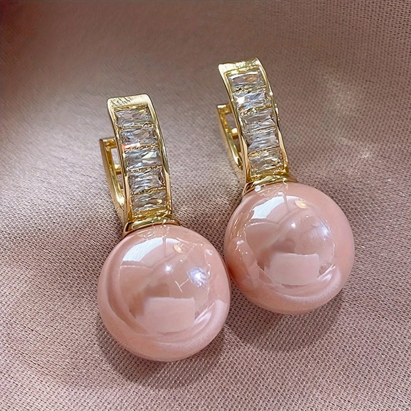 Pendientes huggie de perla rosa con baguettes
