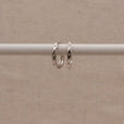 Pendientes huggie plateados en forma de marquesa