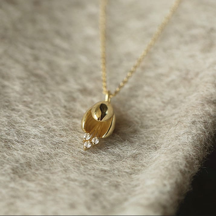 Collar dorado radiante con colgante de gota