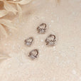 Aros huggie plateados con estrellas de cristal
