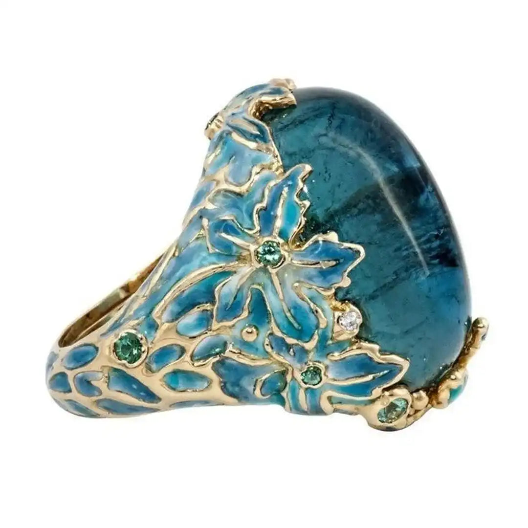 Anillo elegante de oro con flor y piedra azul