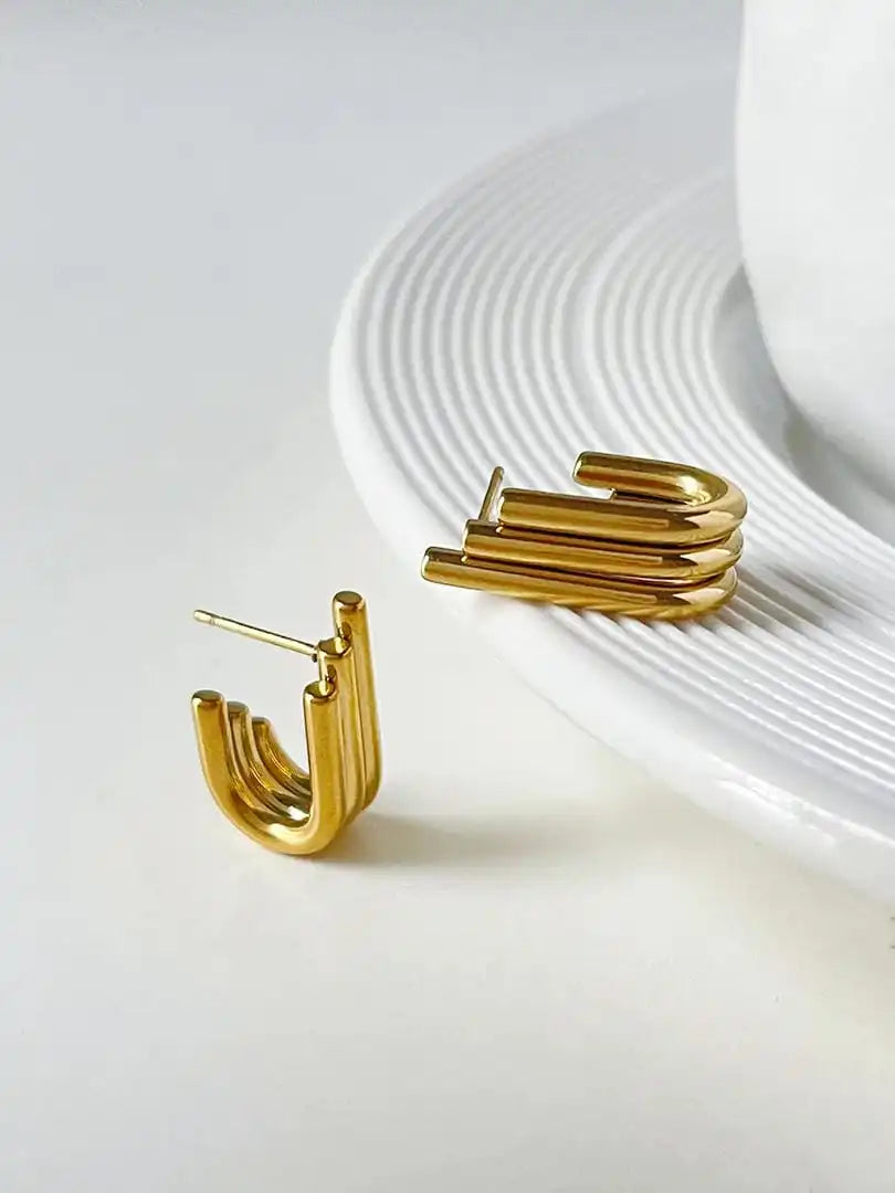Pendientes dorados curvos y acanalados brillantes