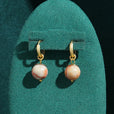 Pendientes dorados modernos con perla esférica