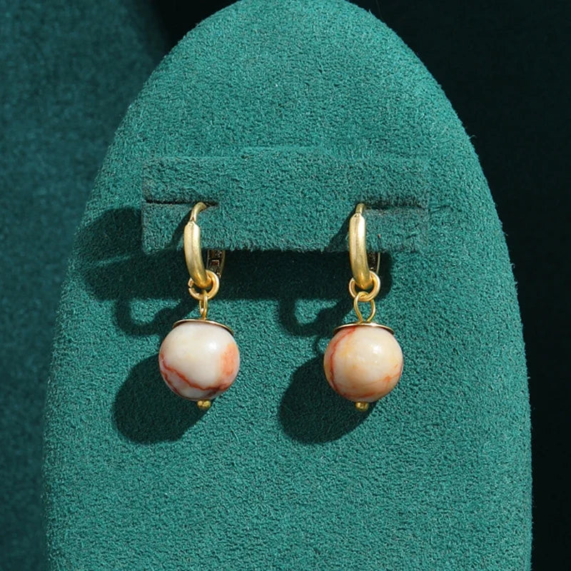 Pendientes dorados modernos con perla esférica