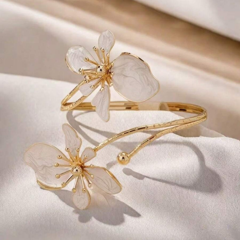 Pulsera rígida dorada con flor de esmalte brillante