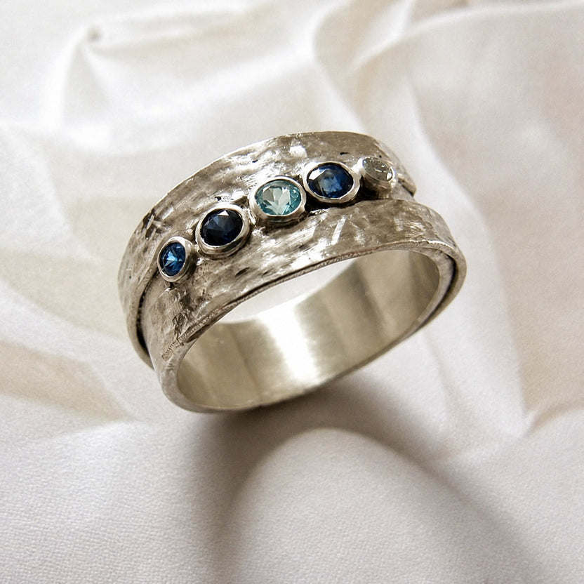 Anillo plateado con piedras azules incrustadas